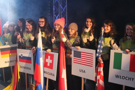Wolontariusze z flagami i tablicami krajów uczestniczących w Pucharze Świata w Wiśle