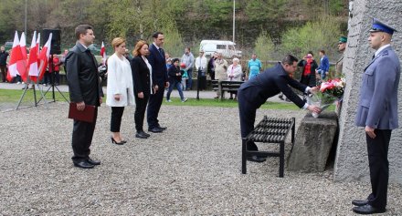 Burmistrz Tomasz Bujok składa wiązankę kwiatów pod pomnikiem