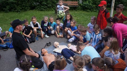 Dzieci uczestniczą w pokazie udzielania pierwszej pomocy