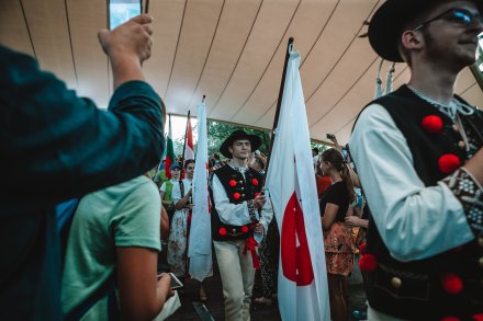 Wolontariusze z flagami wchodzący na scenę
