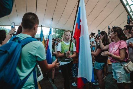 Wolontariusze z flagami wchodzący na scenę