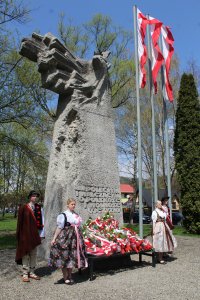 Wiązanki kwiatów przed pomnikiem