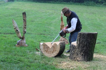 Grzegorz Michałek wycinający piłą spalinową napis Wisła