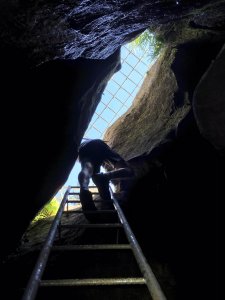 Zejście do jaskini po metalowej drabinie