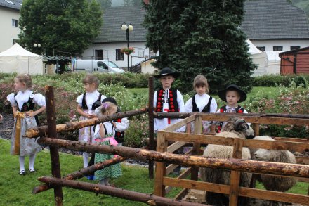 Małe dzieci w góralskich strojach i dwie owieczki
