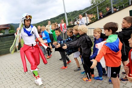 Kamil Stoch przybija "piątkę" z dziećmi obserwującymi trening