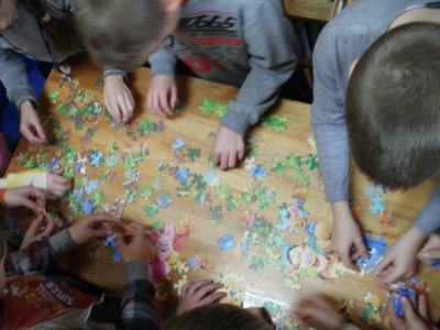 Dzieci układają puzzle z motywem Kubusia Puchatka