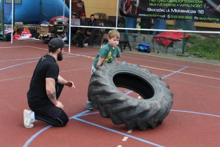 Młody kibic próbuje przetoczyć oponę