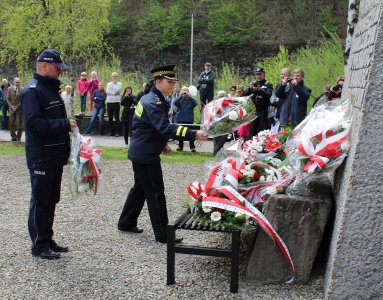 Komendant KP Wisła Marek Legierki i komendantka SM w Wiśle Beata Miś składają kwiaty pod pomnikiem