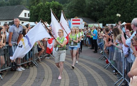 Wolontariusze z flagami wchodzą na scenę