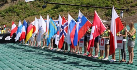 Wolontariusze z flagami na zeskoku skoczni