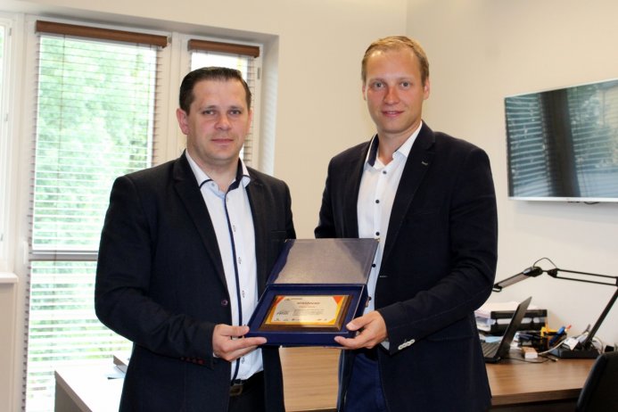 Burmistrz Tomasz Bujok i Marcin Strządała prezentują statuetkę za wyróżnienie dla naszego miasta